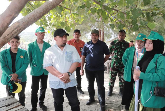 Pj Bupati Aceh Besar Ajak Mahasiswa KKN Pasang Bendera Merah Putih dan Bersihkan Pantai
