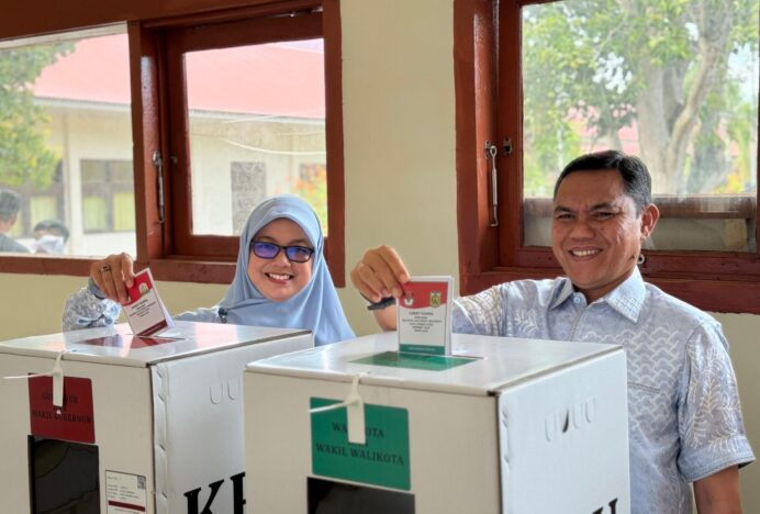 Isnaini dan Istri Gunakan Hak Pilih di TPS 3 Lamteh Ulka Banda Aceh