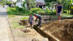 Babinsa Keumireu Bantu Warga Bersihkan Saluran Air