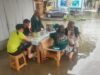 Korban Banjir Makan di Atas Genangan Air