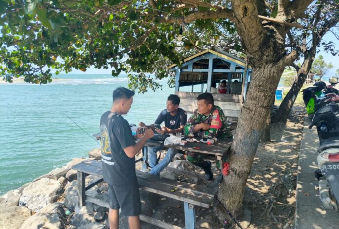 Manfaatkan Waktu Santai, Babinsa Koramil 25/SK Komsos Bersama Warga di Pantai Alue Naga